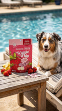 Load image into Gallery viewer, Dog sitting by a pool with a box of 'Wiggle Whip' dog ice cream and strawberries on a wooden table.