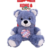 Load image into Gallery viewer, A plush blue-gray bear dog toy with white paws and muzzle, holding a pink, blue, and white braided squeaker, shown with its retail header card against a white background.