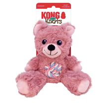 Load image into Gallery viewer, A pink plush Kong toy dog with a colorful braided rope chew attached to its belly, shown on its original retail backing card against a white background.